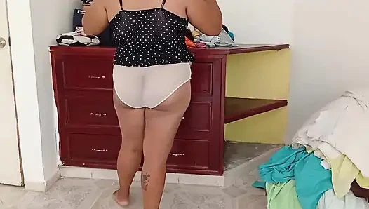 Tombul kız odayı topluyor ve kıyafetlerini katlıyor