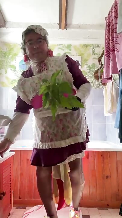 แต่งตัวในเสื้อผ้าทําสวน เธอเฆี่ยนตัวเองด้วยใบหนา