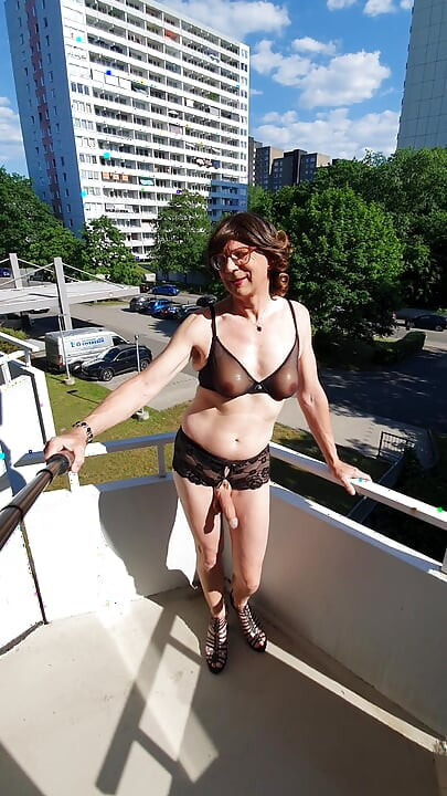 Pointing on the balcony in lingerie