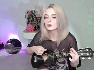 Hot blonde girl playing on ukulele and singing in naughty outfit
