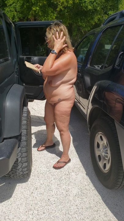 Gordinha milf está nua do lado de fora. se preparando para um dia de nudez no resort nudista.