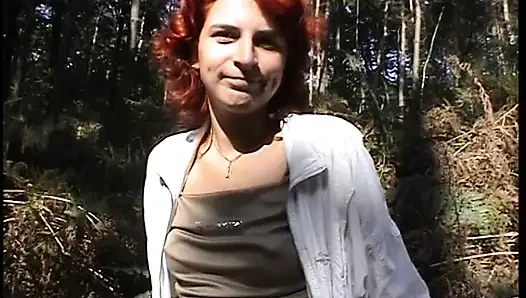 Redhead chick plays with her pussy outdoors