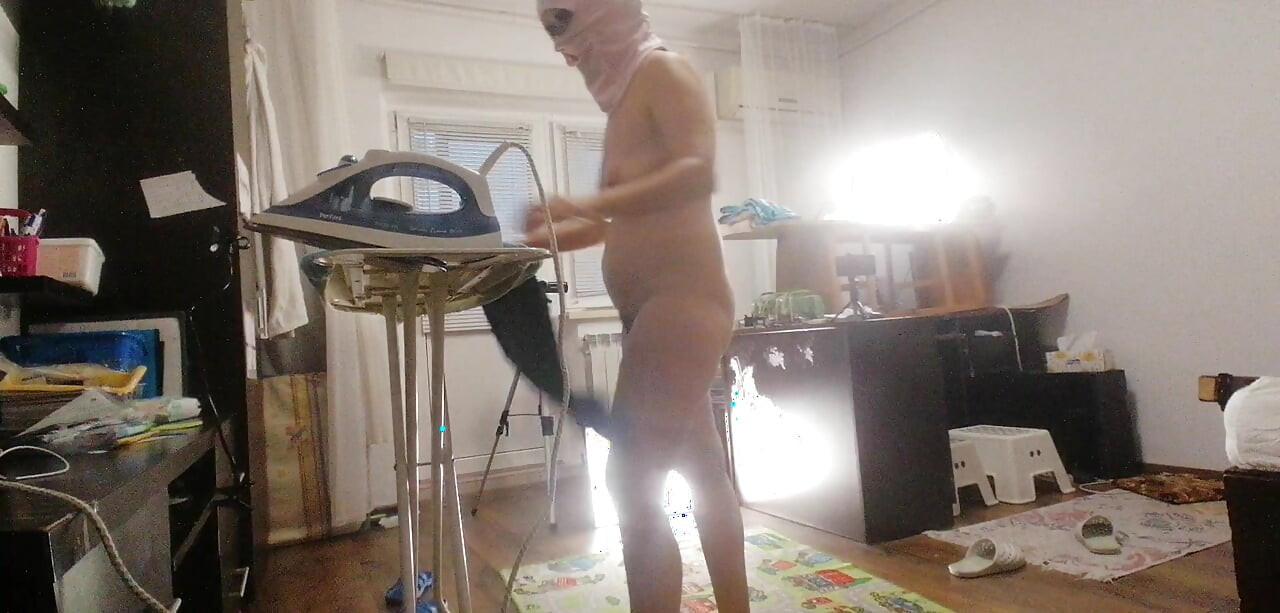 Sexy brunette doing naked chores around the house