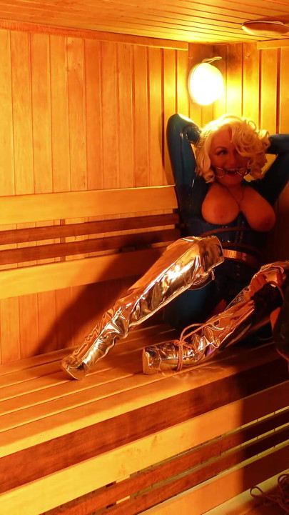 Bondage process in the sauna: sexy gagged submissive MILF in latex and her rubber dominatrix