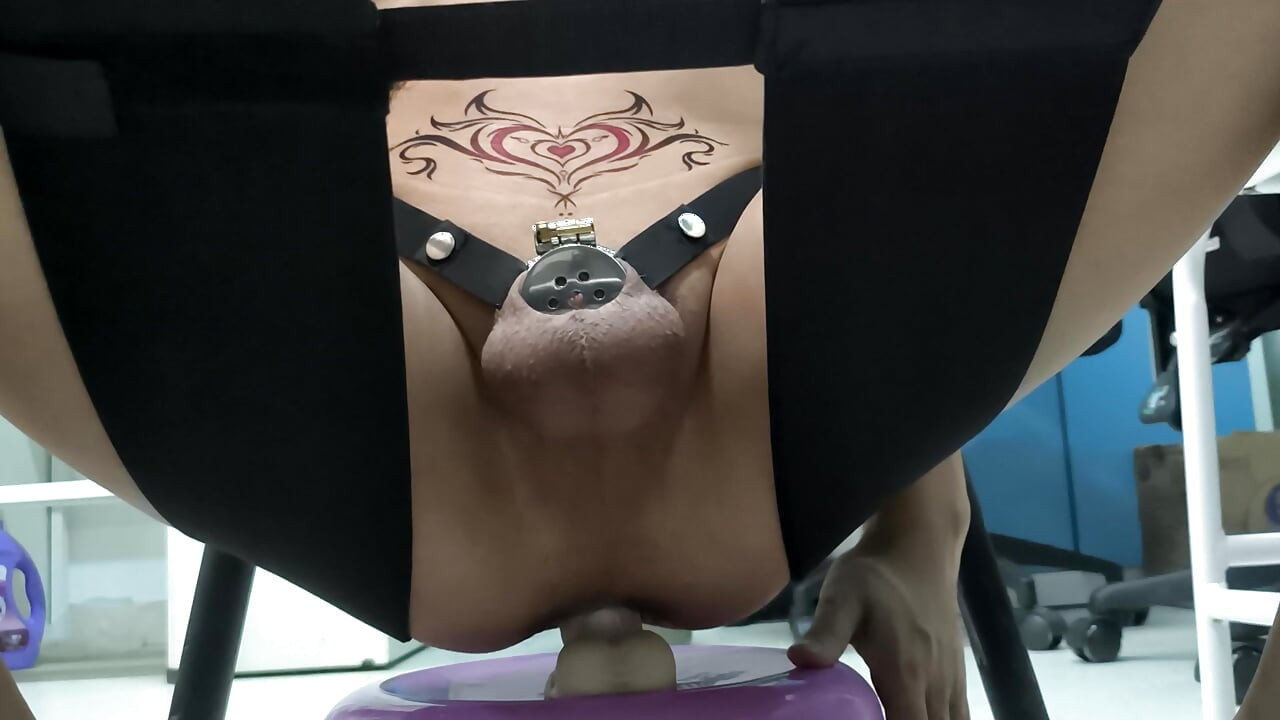 Sitting in a chair and using a dildo to masturbate in chastity