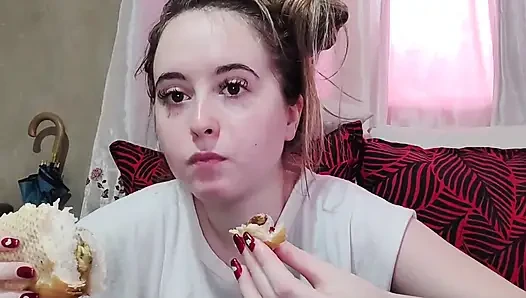 Memakan sandwich omelet dengan tomat ceri