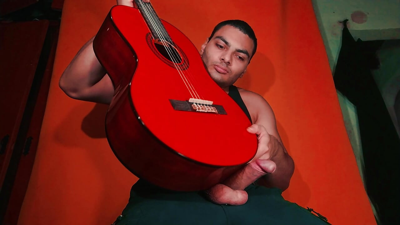 Masturbation of large penis on carrot colored background - GuitarJob - Guitar Masturbation