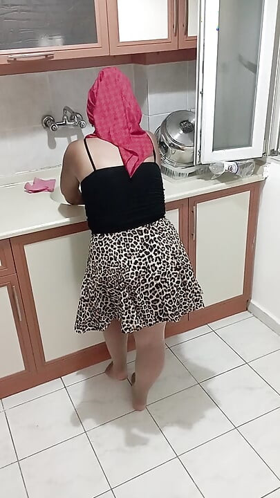 Wdowa w chuście myje naczynia.