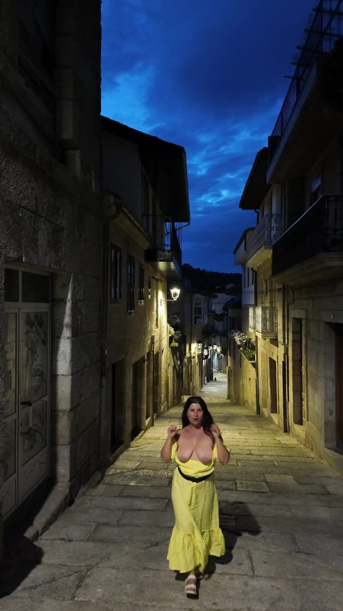 Hot milf shows off her breasts on a Spanish street.