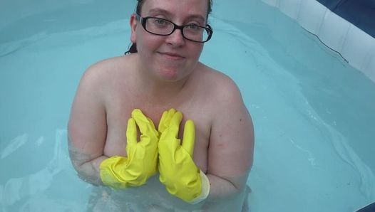 Guanti di gomma nudista nella vasca idromassaggio