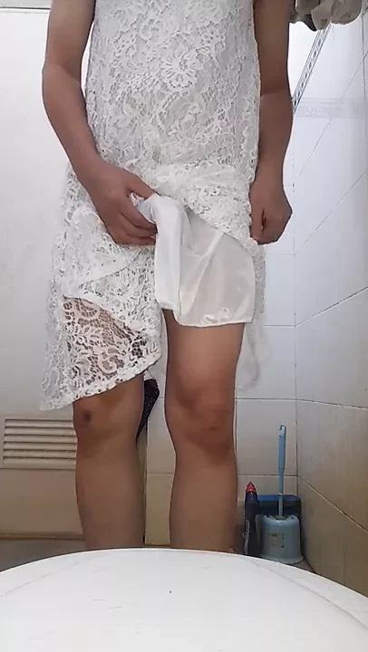 Crossdresser usando vestido branco e gozando