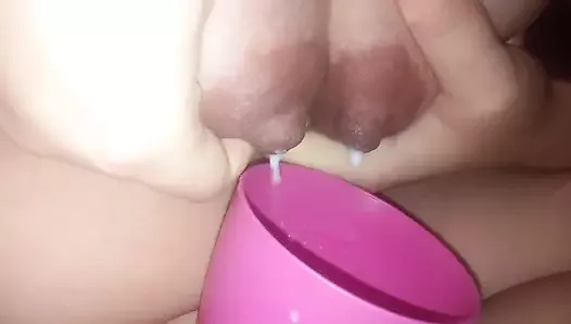 Young mom pours milk from boobs into a cup