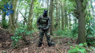 Szczeniak żołnierza drapie się w lesie