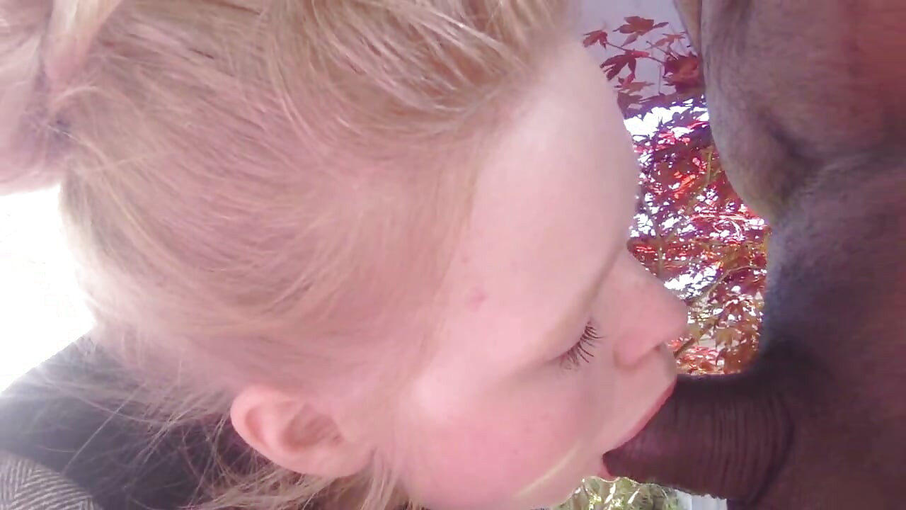 Blond tonåring suger svart kuk i trädgården blowjob