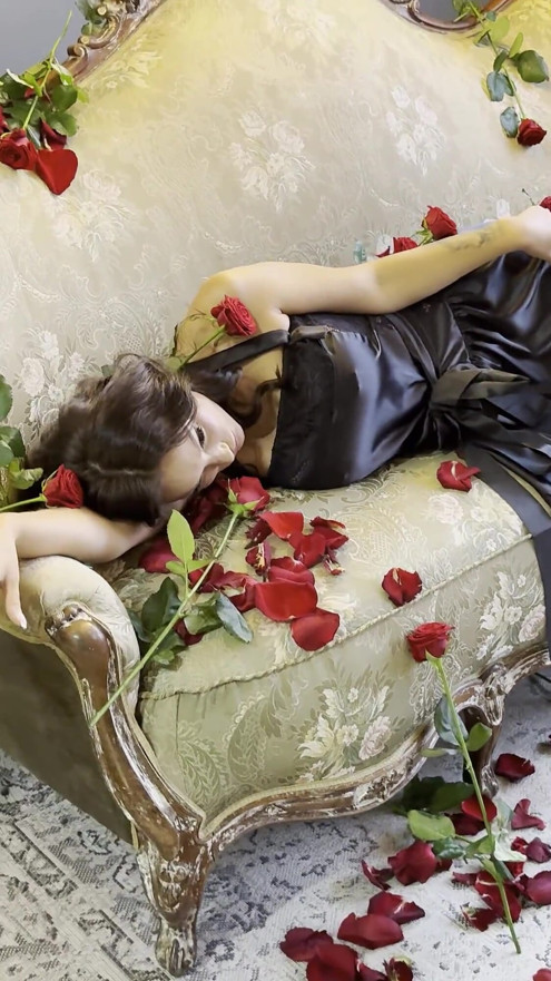 Schöne Monika Fox im schwarzen Kleid auf dem Sofa mit Rosen!