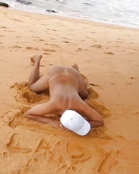 Ladysilva goală pe plajă își expune fundul sexy de bronz cu o linie de bronz sexy