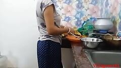Esposa en un sari rojo en la cocina