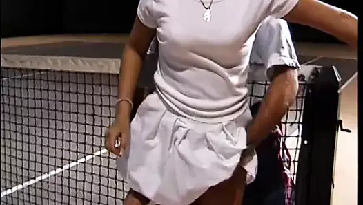 Une jeune brune mignonne avec des dreadlocks prend des cours de tennis avec un entraîneur vigoureux