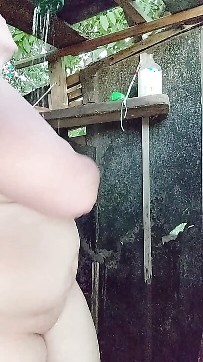 I'm watching a curvy girl wash herself in the street.