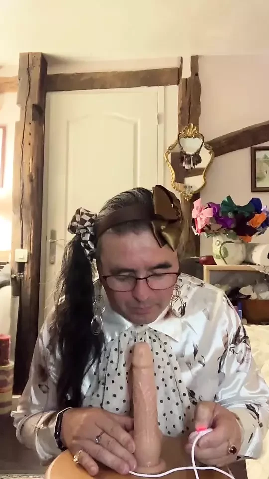 In an outfit with a little brown skirt to suck a dildo