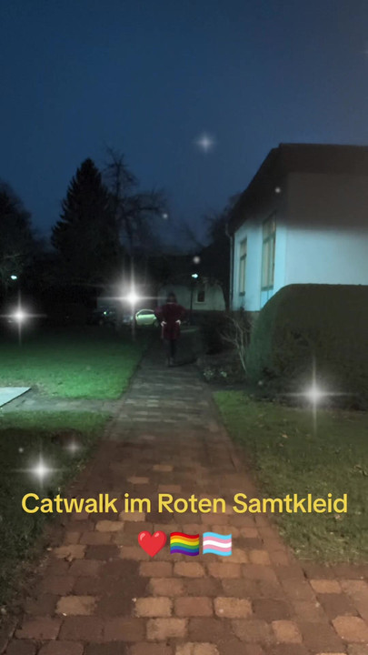 赤いベルベットのドレスでランウェイを歩く。