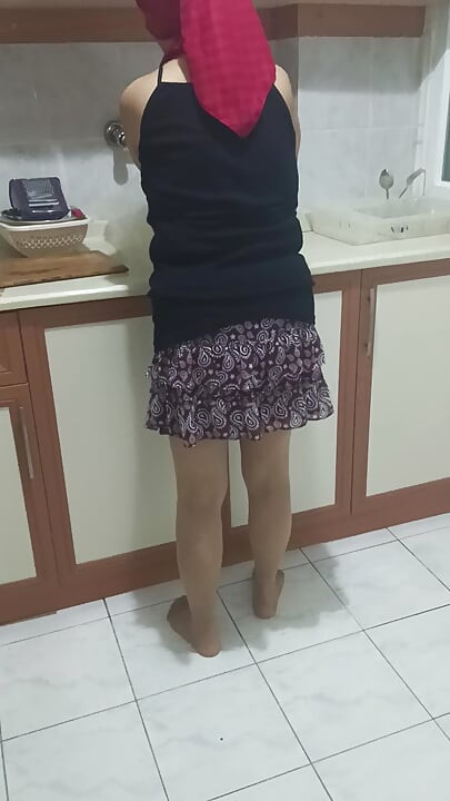 Mature woman in sheer stockings doing housework in the kitchen.