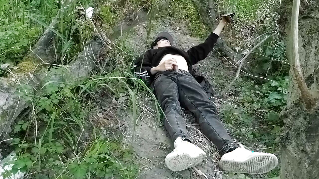 This gay twink sticks his cock through his fly to jerk off outside