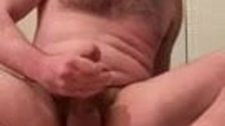 Behaarter Mann beschuht seine fiesen Füße, während sein Penis Sperma kommt