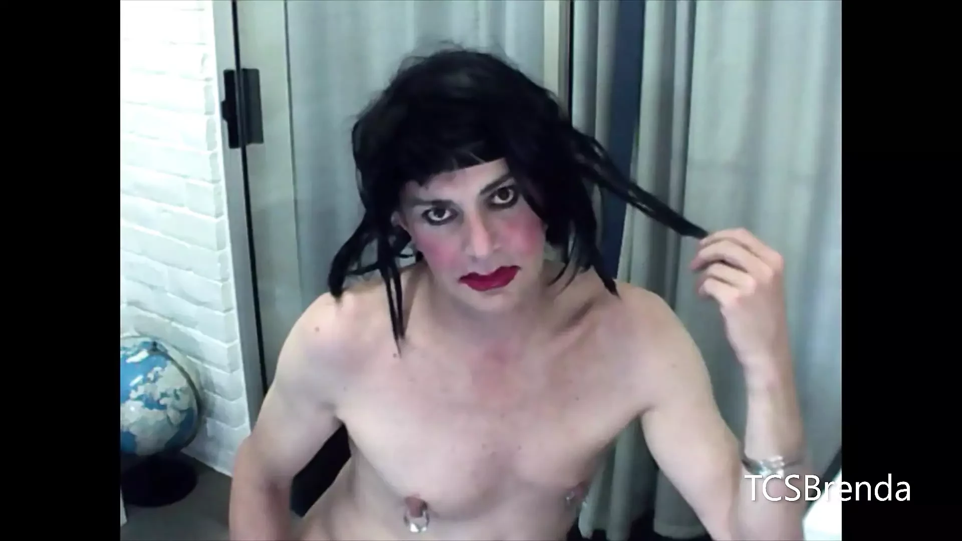 Travestiet tandeloos glimlachend met rode lippenstift op webcam.