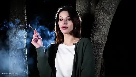 Gadis manis rusia merokok siang hari di luar ruangan