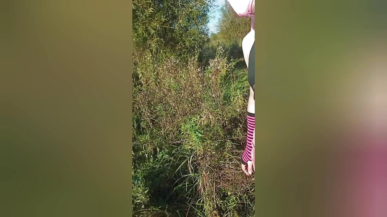 Uma sissy puta jovem, sexy e depravada desp<PRIVATE_DATE> nua no bosque e fode-se com avidez.