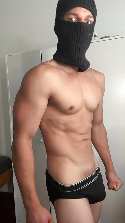 Masked young hunk showing off his muscles