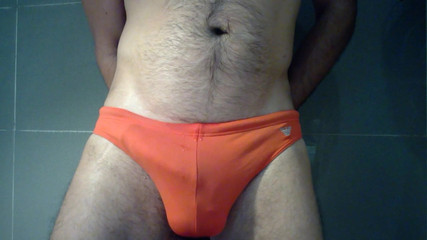 Vollbusig in orangefarbenen Speedos