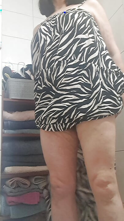 in the bathroom showing what's under her dress to her young lover on camera