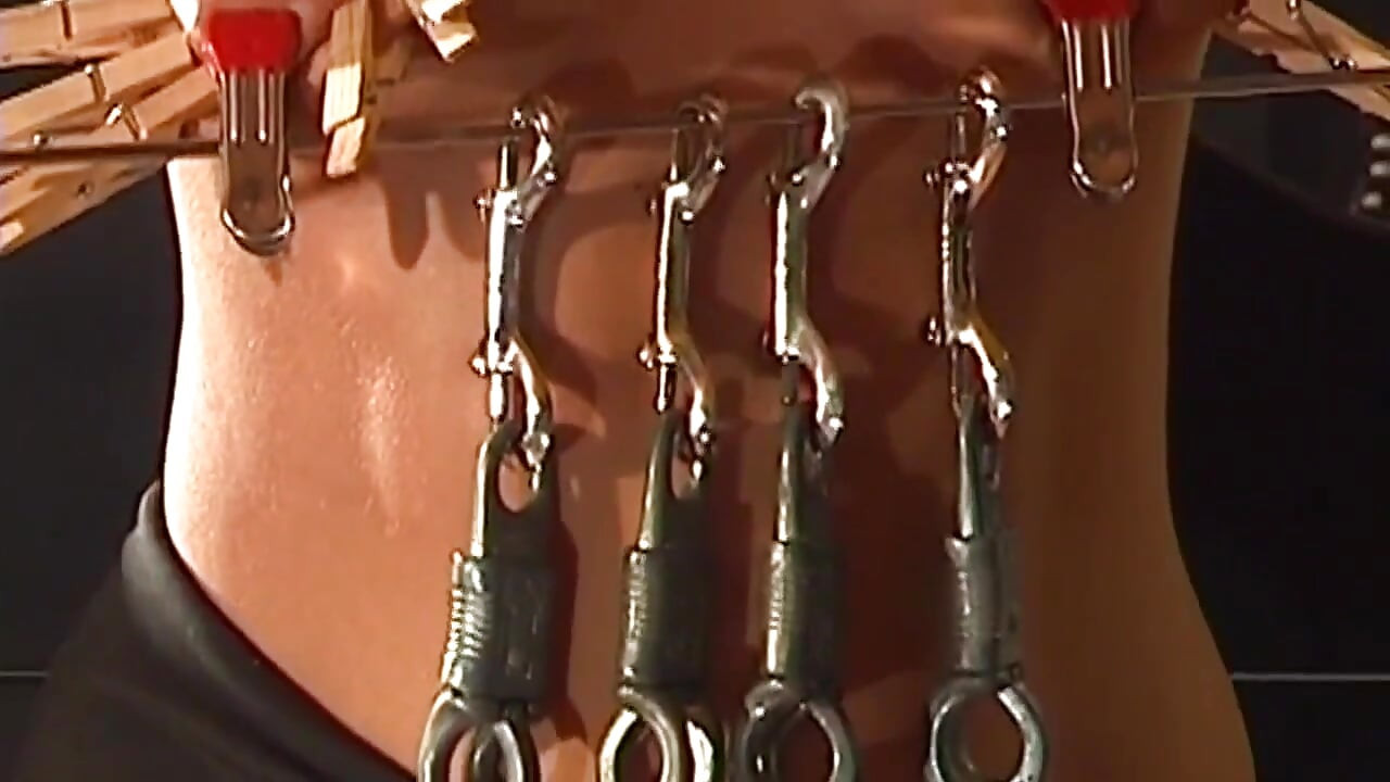 Une MILF blonde tatouée endure des pinces à tétons intenses, bondage