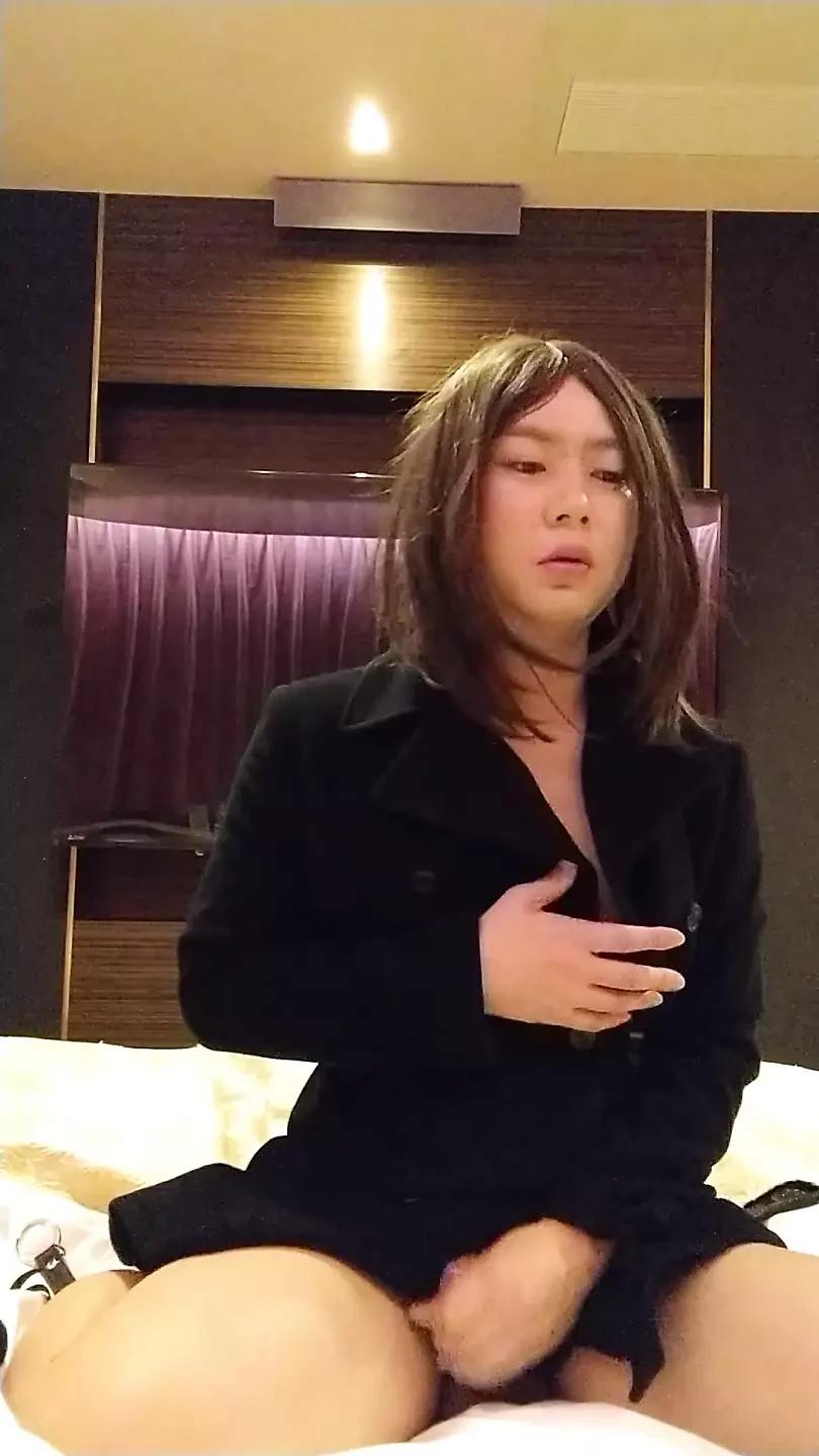 Een cross-dressing jongen in zwarte full-body panty met een kraag begint uit te trekken en masturbeert in zijn ondergoed.