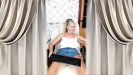 Fröhliche hausfrau Lukerya flirtet in engen jeansshorts in der küche.