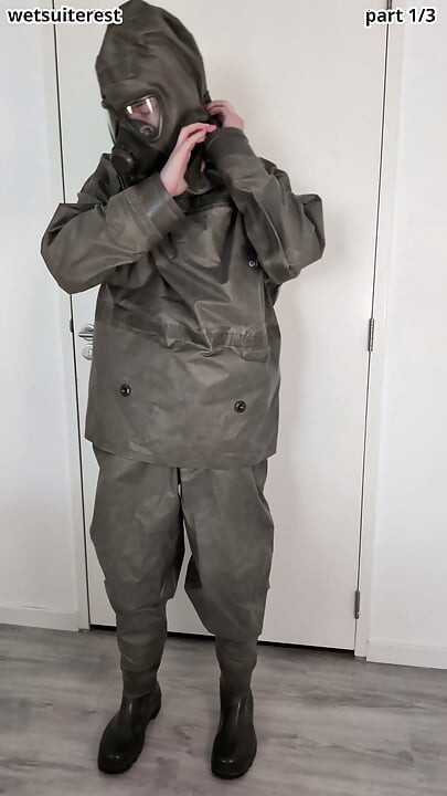 Putting on Zodiac Zodiak heavy rubber hazmat suit over plastic pants and gas mask