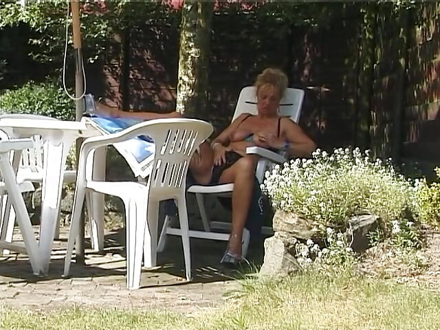 Sarışın orta yaşlı seksi kadın açık havada göğüslerini gösteriyor