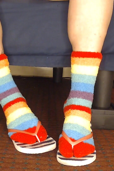 Des tongs et des chaussettes floues moelleuses jouent avec des chaussures.