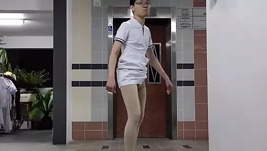 Vestindo vestido de enfermeira, meia-calça branca da enfermeira e sapatos de enfermeira.