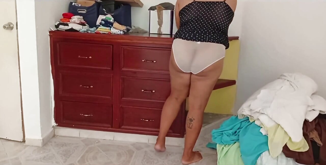 Tombul kız odayı topluyor ve kıyafetlerini katlıyor