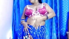 Hintli ateşli seksi güzel kız kıyafetlerini açıyor ve göğüslerini açıyor ve erotik dans ediyor.