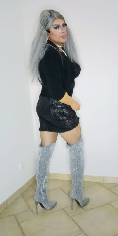 Pretty slutty mature transvestite shows off her curves in fishnet tights and thigh-high boots