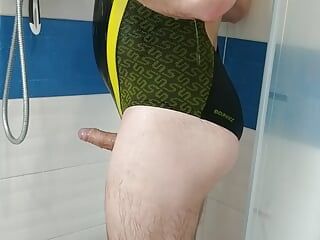セクシーなspeedoのワンピース水着姿の少年がシャワーを浴びる