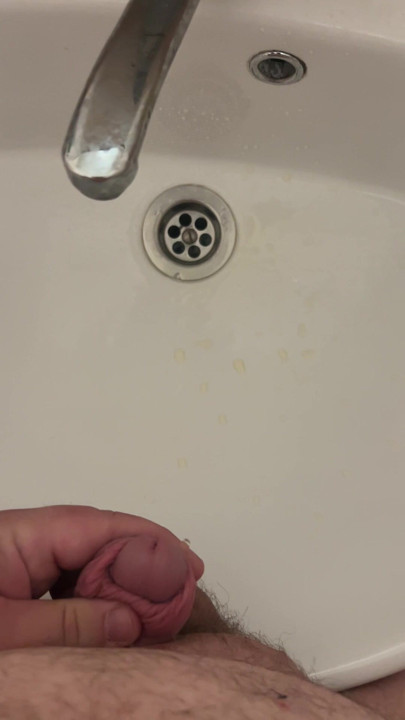 Fat man with a small dick pees in the sink