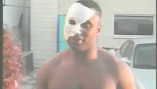 Muskulöse fremder in weißer Superheldin-Maske bohrt ebenholzküken auf dem Parkplatz des Einkaufszentrums