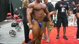 Str8 bodybuilder greco che flette nel backstage