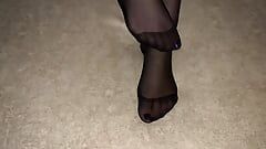 Mädchen zeigt ihre sexy Füße in schwarzen Nylonstrumpfhosen