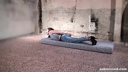 Связанная по рукам и ногам Adel с кляпом во рту